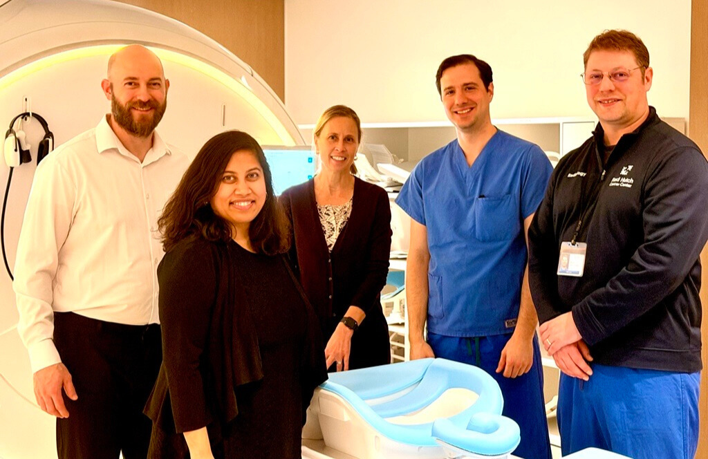 Researchers Dallas Turley, PhD, Debosmita Biswas, MS, Savannah Partridge, PhD, Michael Senff, RT(R)(MR)MRSO, and Kevin Widner (left to right) stand in front of a magnetic resonance imaging (MRI) scanner during a collaborative breast imaging project.