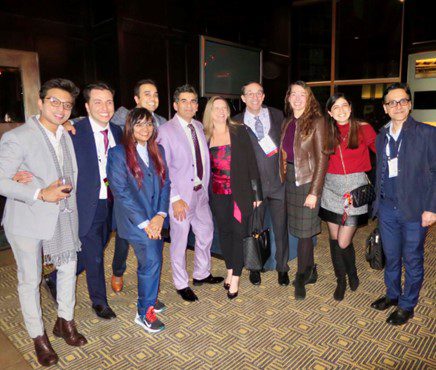 RSNA attendees from UW pose for a photo. They wear semi-formal attire and appear happy and relaxed.